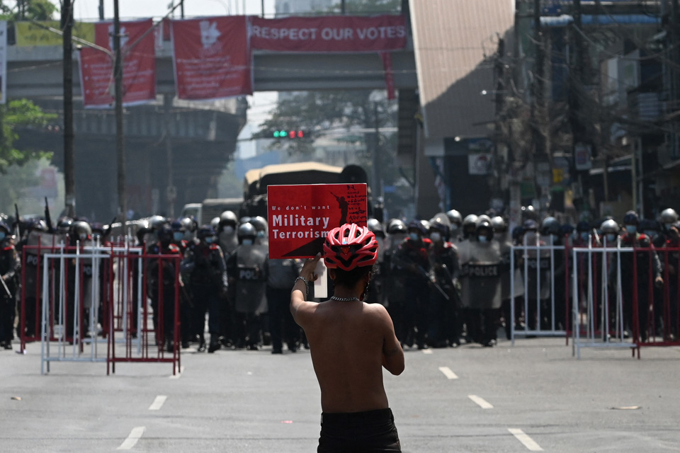 လုံခြုံရေးတပ်ဖွဲ့ဝင်များနဲ့ ဒီမိုကရေစီတိုက်ပွဲဝင်နေသူ တစ်ဦး (ပုံ-AFP)