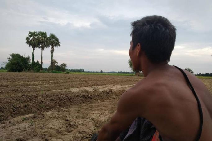 တမံကျိုးပေါက်မှုအပြီးပျက်ဆီးဆုံးရှုံးသွားသည့် လယ်ယာမြေများအား ကြည့်နေသည့် ဒေသခံတောင်သူတစ်ဦး။