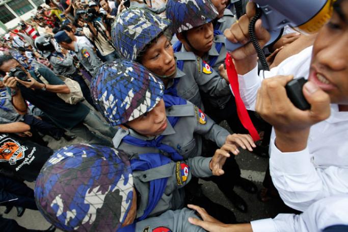 ဖွဲ့စည်းပုံအခြေခံဥပဒေ ပြင်ဆင်ရေးအတွက် ရန်ကုန်မြို့ မြို့တော်ခန်းမရှေ့တွင် ဆန္ဒပြသည့် ကျောင်းသား၊ ပြည်သူများကို ရဲတပ်ဖွဲ့ဝင်များက ပိတ်ဆို့ တားဆီးနေသည်ကို ဇွန် ၃၀ရက် ညနေပိုင်းက တွေ့ရစဉ်။ (ဓာတ်ပုံ- ဟောင်ဆာ(ရာမည))
 