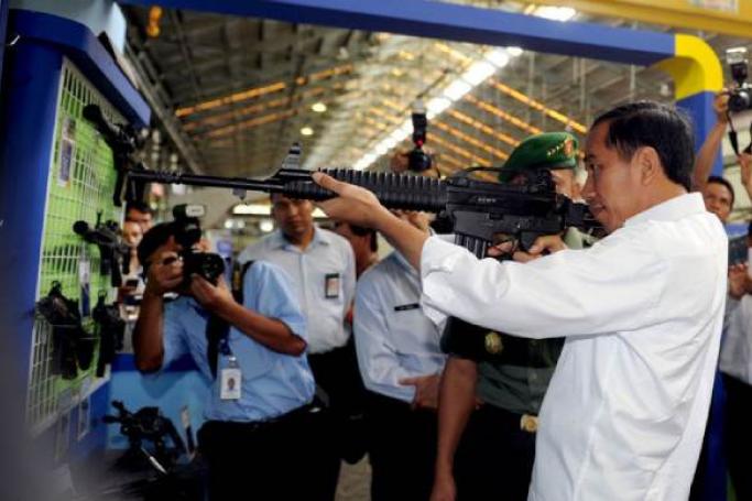 အင်ဒိုနီးရှားသမ္မတ Joko “Jokowi” Widodo သည် ဇန်နဝါရီ ၁၂၊ ၂၀၁၅၊ ဂျာဗား၊ ဘန်ဒေါင်းမြို့ရှိ အစိုးရပိုင် PT Pindad စက်ရုံသို့ သွားရောက်လည်ပတ်စဉ် သေနတ်တစ်လက်အား စစ်ဆေးကြည့်ရှုနေစဉ် [Rusman/Presidential Palace via AFP]