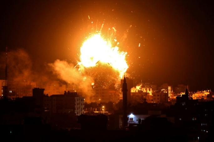A picture taken on November 12, 2018 shows a ball of fire above the building housing the Hamas-run television station al-Aqsa TV in Gaza City during an Israeli air strike. Photo: AFP