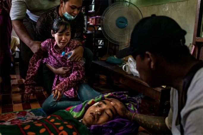 A sister of Chit Min Thu, 25, who was killed in clashes, mourns next to his body during his funeral at the family’s home last week in Yangon, Myanmar. Photo by stringer 