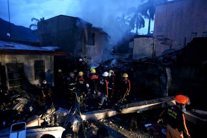 Filipino firefighters search for bodies at the site where an air ambulance crashed and killed nine people, all believed to be aboard the plane, at a resort area in Calamba City, Laguna province, south of Manila (AFP Photo/STR)