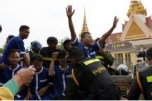 ကမ္ဘောဒီးယား အမျိုးသားလွှတ်တော် အဆောက်အအုံရှေ့ အကျဉ်းသားဝတ်စုံဝတ်ထားသည့် ဆန္ဒပြသူများကို ရဲတပ်ဖွဲ့ ထိန်းသိမ်းစဉ်။ ဓာတ်ပုံ-အေအက်ဖ်ပီ