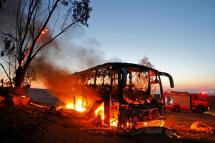 A picture taken on November 12, 2018 shows a bus set ablaze after it was hit by a rocket fired from the Gaza Strip, at the Israel-Gaza border near the kibbutz of Kfar Aza, on November 12, 2018. Photo: AFP