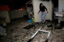An Israeli woman inspects the damage in an apartment that was hit by a rocket fired from the Gaza Strip, in the southern Israeli town of Ashkelon on November 12, 2018. Photo: AFP