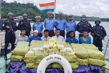 Indian Coast Guard personnel, up, pose for photographs as they keep watch on a Myanmarese ship's crew after seizing Ketamine drug from their boat near Car Nicobar islands, part of the Indian union territory of Andaman and Nicobar islands on September 19, 2019 AFP